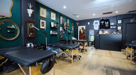 Chic interior of The Hanged Man Tattoo & Barber, Manly, New South Wales, AU, showcasing art and tattoos.