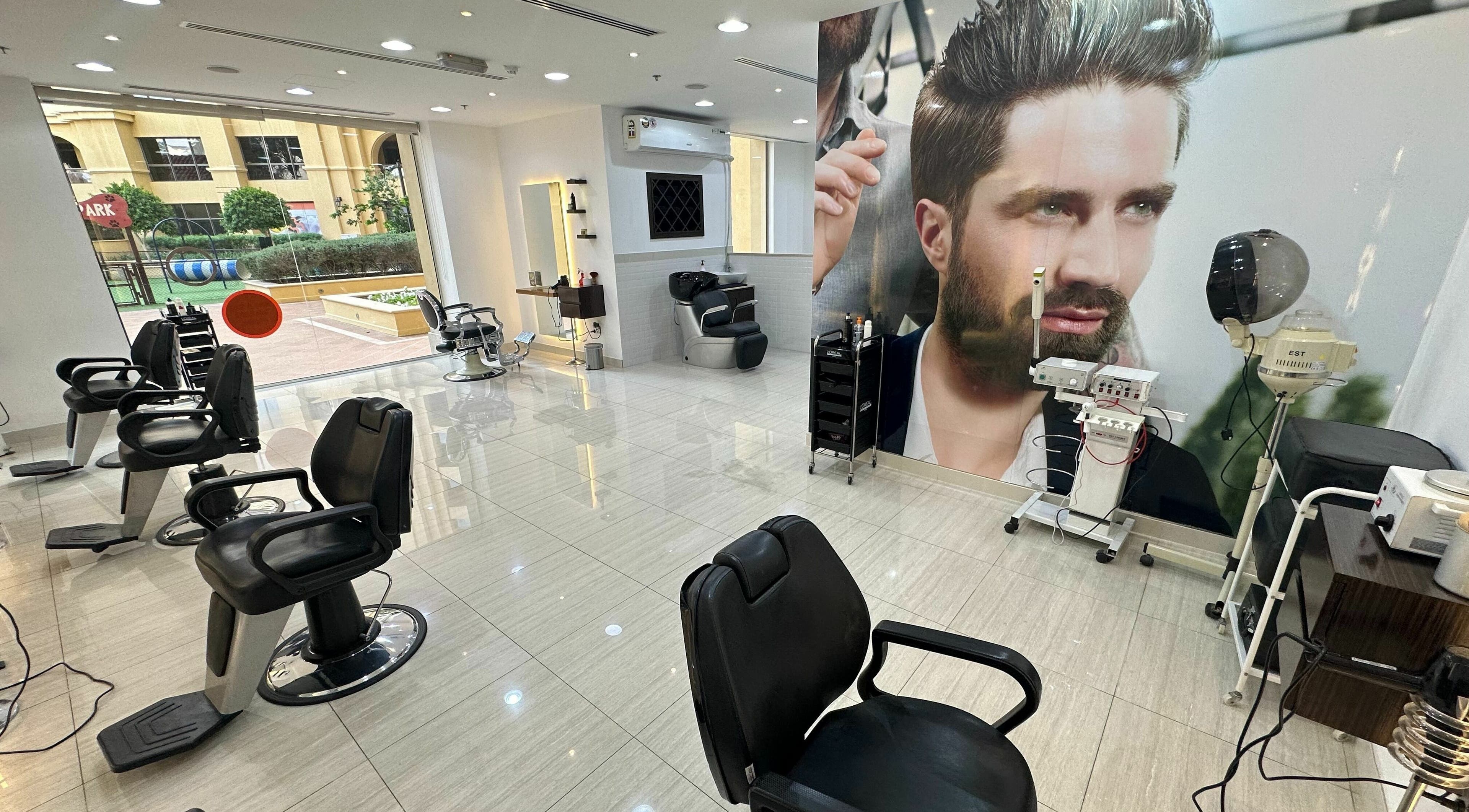 Stylish interior of Barber District in دبي, دبي, AE with modern barber chairs and bright lighting.