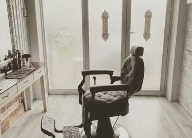 Vintage barber chair in Barber James, East London, Eastern Cape, ZA, bathed in natural light.