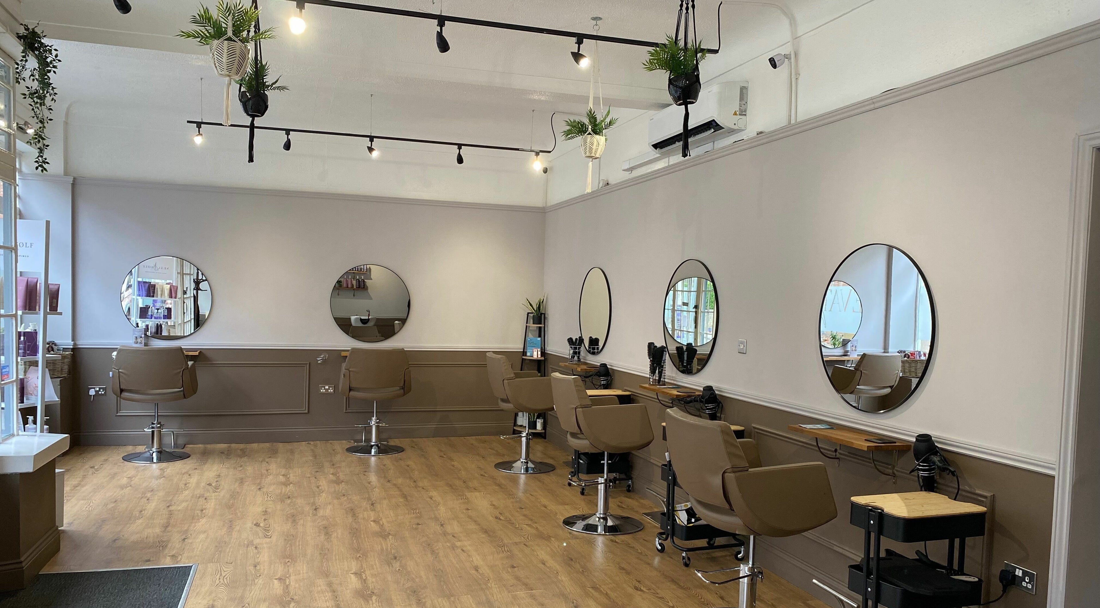 Modern salon interior at Elevate Hair in Bury St Edmunds, England with stylish mirrors and seating.