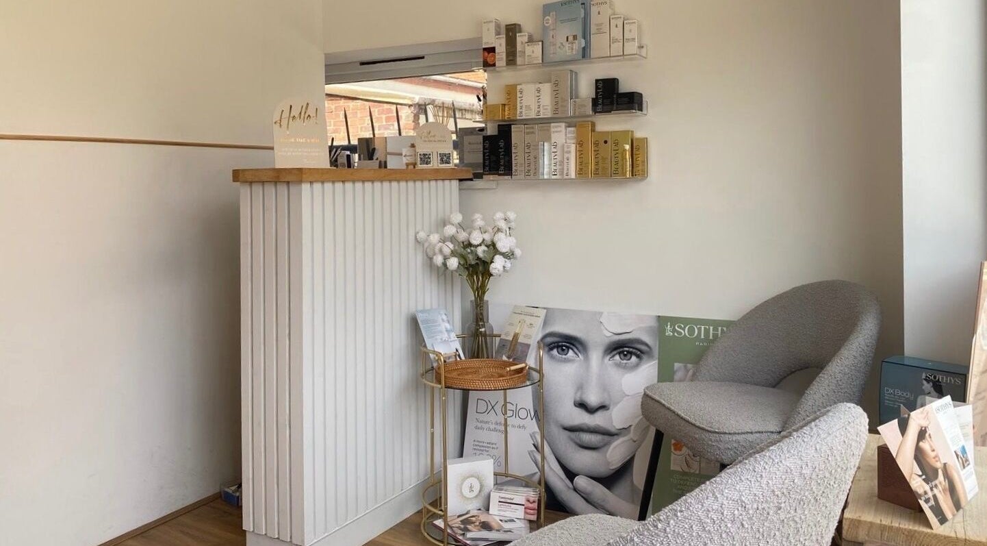 Elegant reception area at The Ultimate Touch Beauty, Wymondham, England. Cozy seating with beauty product displays.