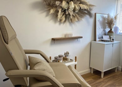 Relaxing treatment room at The Ultimate Touch Beauty, Wymondham, England, GB with a cozy chair and soothing decor.