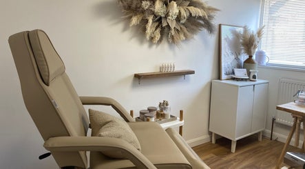 Relaxing treatment room at The Ultimate Touch Beauty, Wymondham, England, GB with a cozy chair and soothing decor.