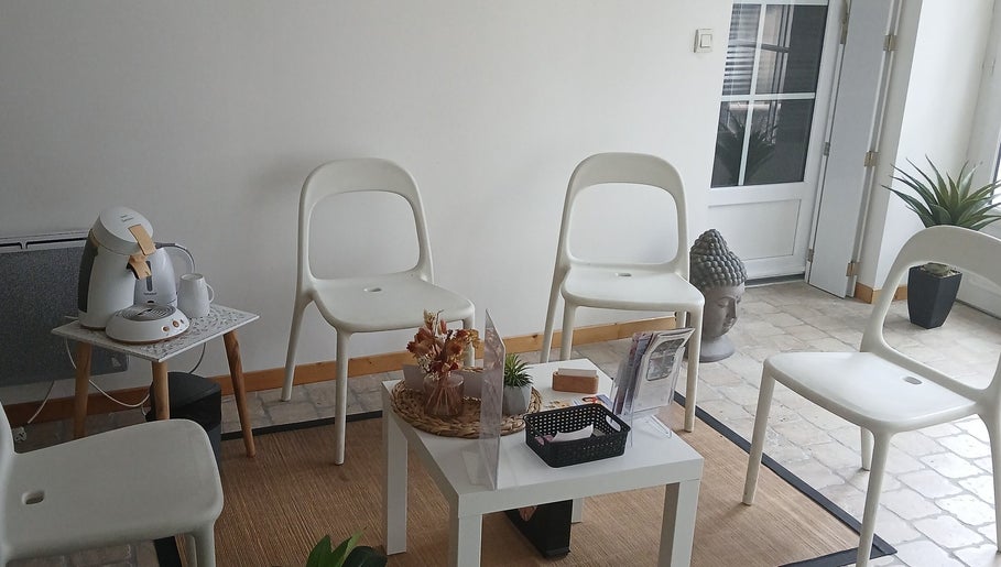 Espace d'attente à La Douce'heure Esthétique, Nouzilly, Centre-val De Loire, FR, avec chaises blanches et déco zen.