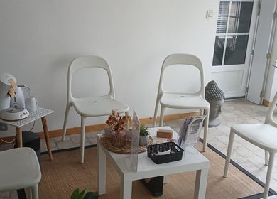 Espace d'attente à La Douce'heure Esthétique, Nouzilly, Centre-val De Loire, FR, avec chaises blanches et déco zen.