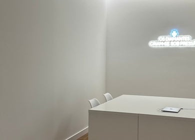 Sala minimalista no MUSE, São Domingos De Rana, Lisboa, PT, com mesa branca e iluminação suave.