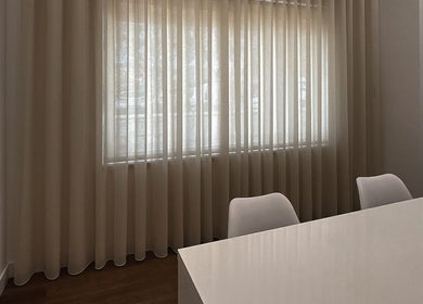 Espaço de trabalho tranquilo na MUSE, São Domingos De Rana, Lisboa, PT, com cortinas claras e mesa branca.
