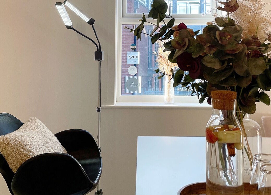 Aesthetic setup at The Brow Project, Sheffield, England, GB, featuring a chair, lighting, and floral decor.