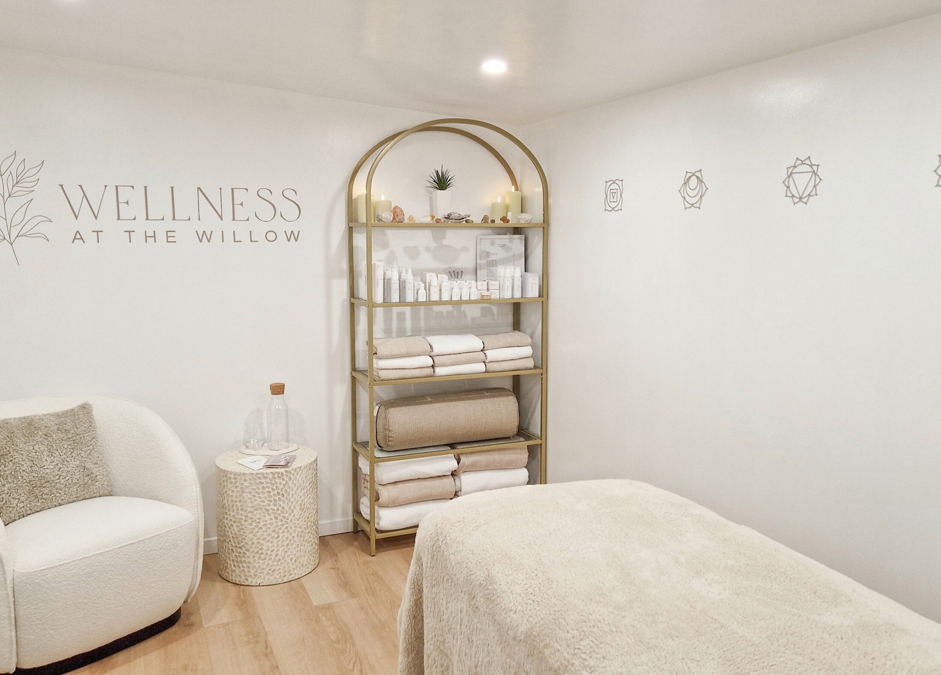 Tranquil treatment room at Wellness at The Willow, Leyland, England, GB with cozy chair and shelves of products.