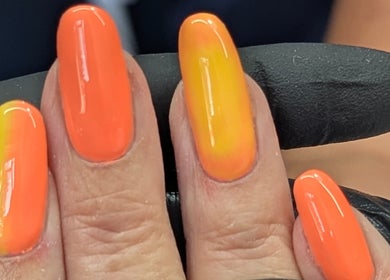 Vibrant orange and yellow gradient nails at Trulyou, Swindon, England, GB. Perfect for beauty lovers.