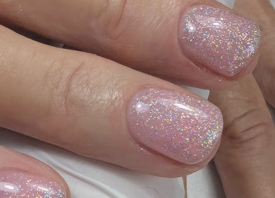 Sparkling nail art at Trulyou in Swindon, England, GB. A shimmering pink polish enhances beauty.