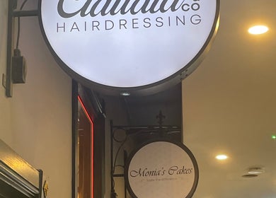 Claudia & Co Hairdressing sign at Warrington, England, GB, illuminated in a modern interior.