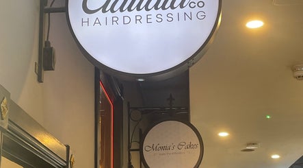 Claudia & Co Hairdressing sign at Warrington, England, GB, illuminated in a modern interior.