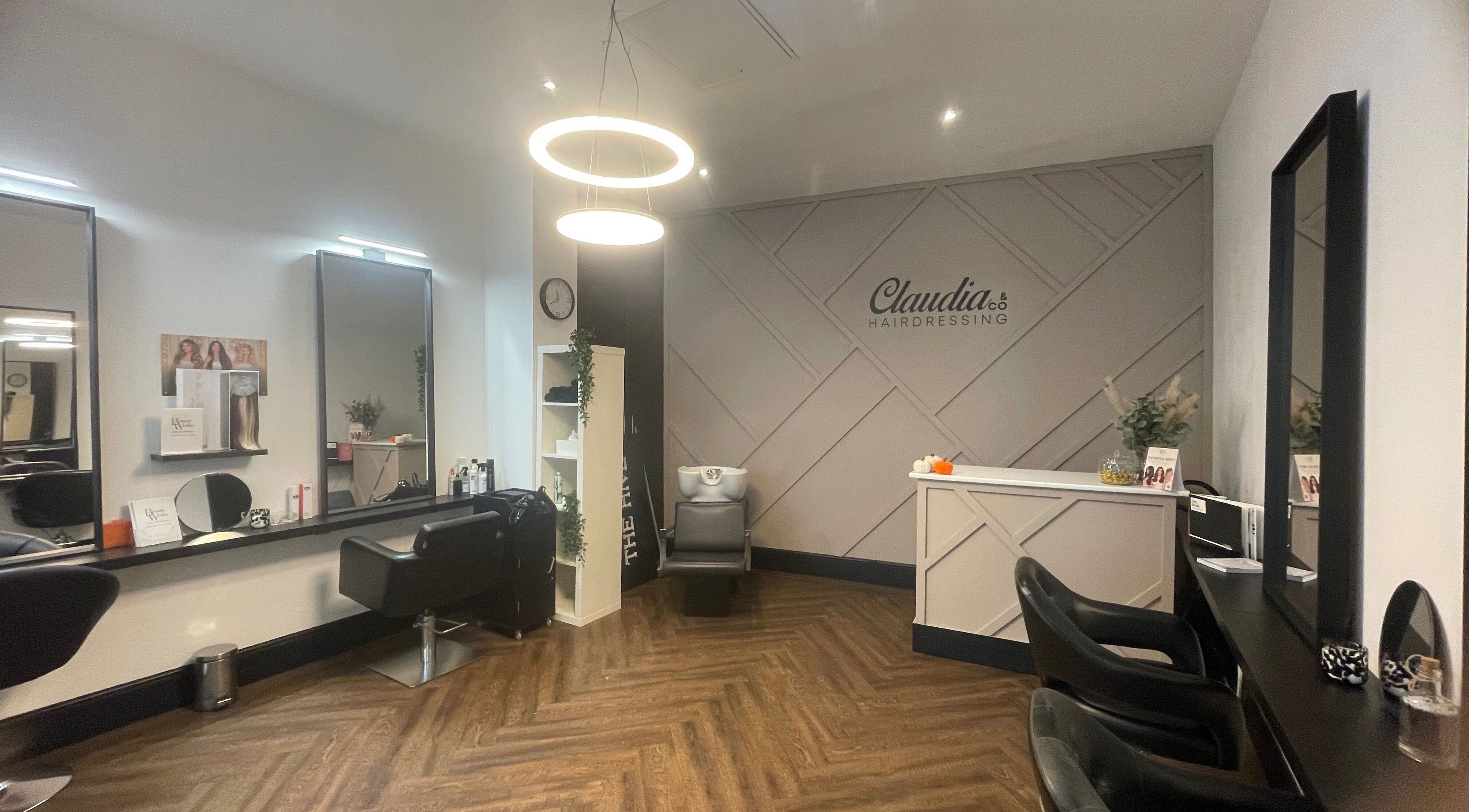 Modern salon interior at The Hair Casa, Warrington, England, GB, with sleek chairs and elegant lighting.