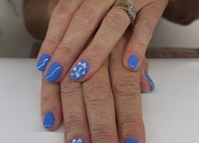 Nail art with blue polish and designs at Maddie's Beauty Room, Great Baddow, England, GB.