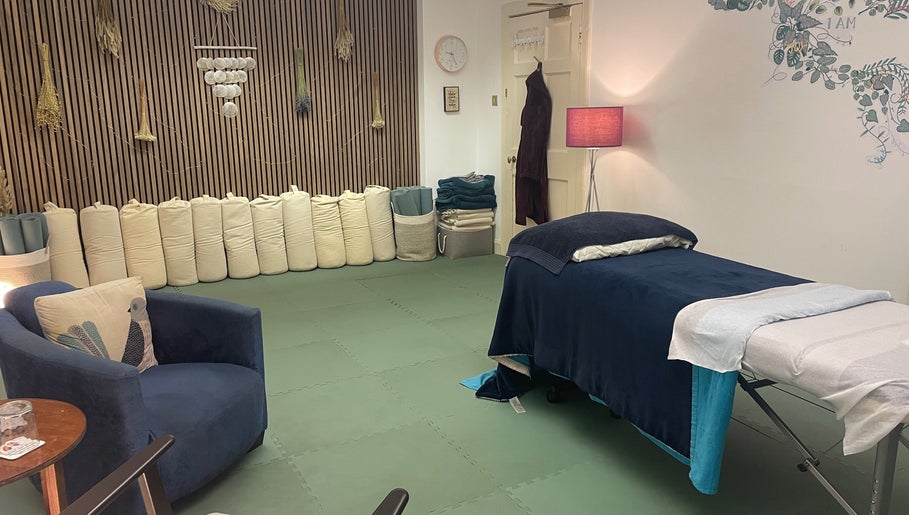 Tranquil therapy room at Calmer Being, Edinburgh, Scotland, GB, featuring a massage table and cozy seating.