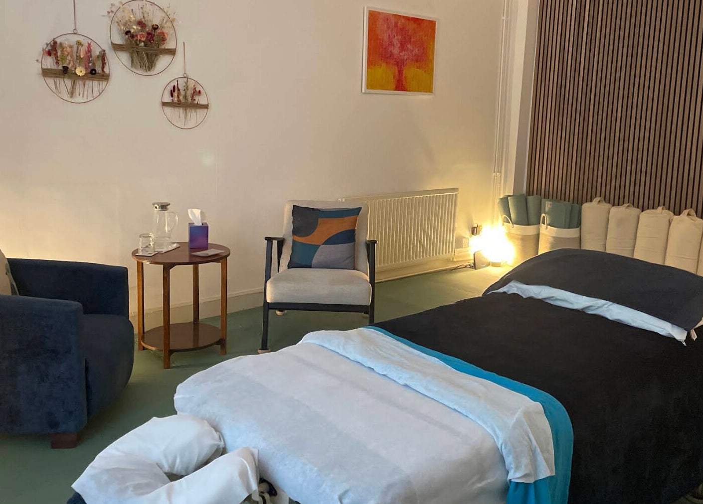 Serene wellness room at Calmer Being, Edinburgh, Scotland, GB, with a massage table and cozy seating.
