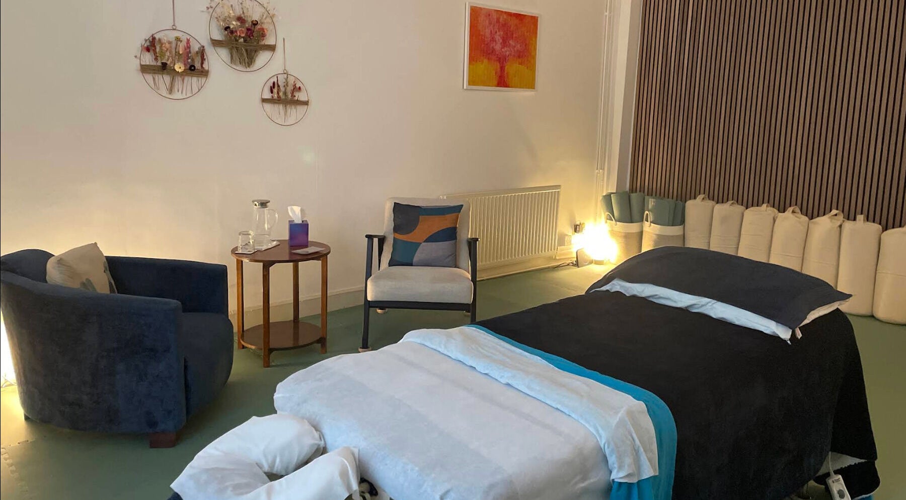 Serene wellness room at Calmer Being, Edinburgh, Scotland, GB, with a massage table and cozy seating.