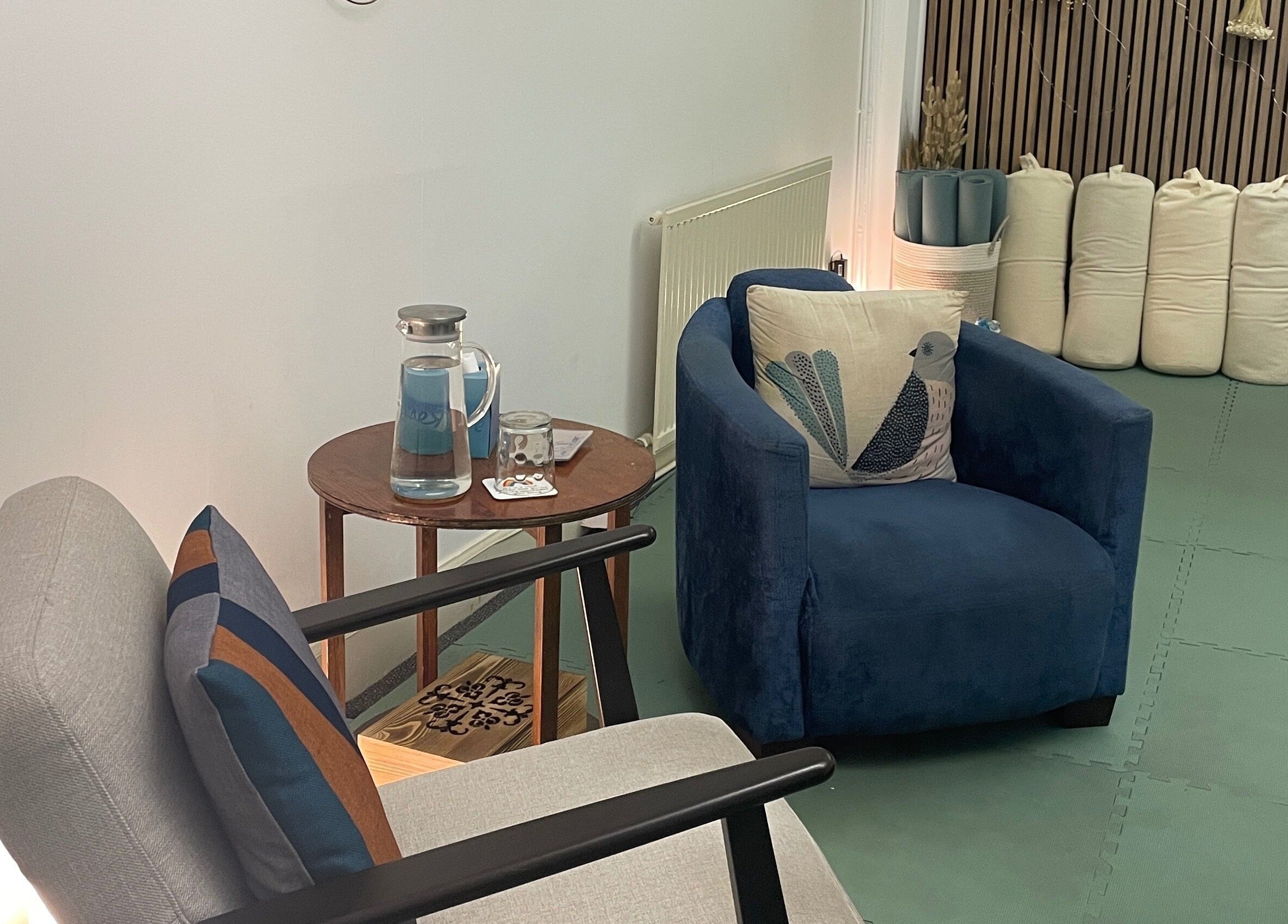 Relaxing lounge area at Calmer Being in Edinburgh, Scotland, GB with plush chairs and a wooden table.