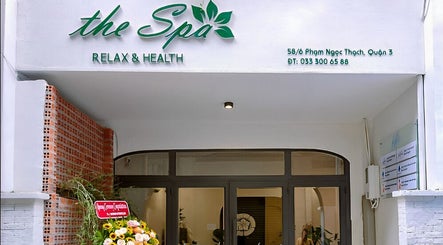 Entrance of The Spa Saigon in Thành Phố Hồ Chí Minh, VN showcasing modern facade with floral decor.