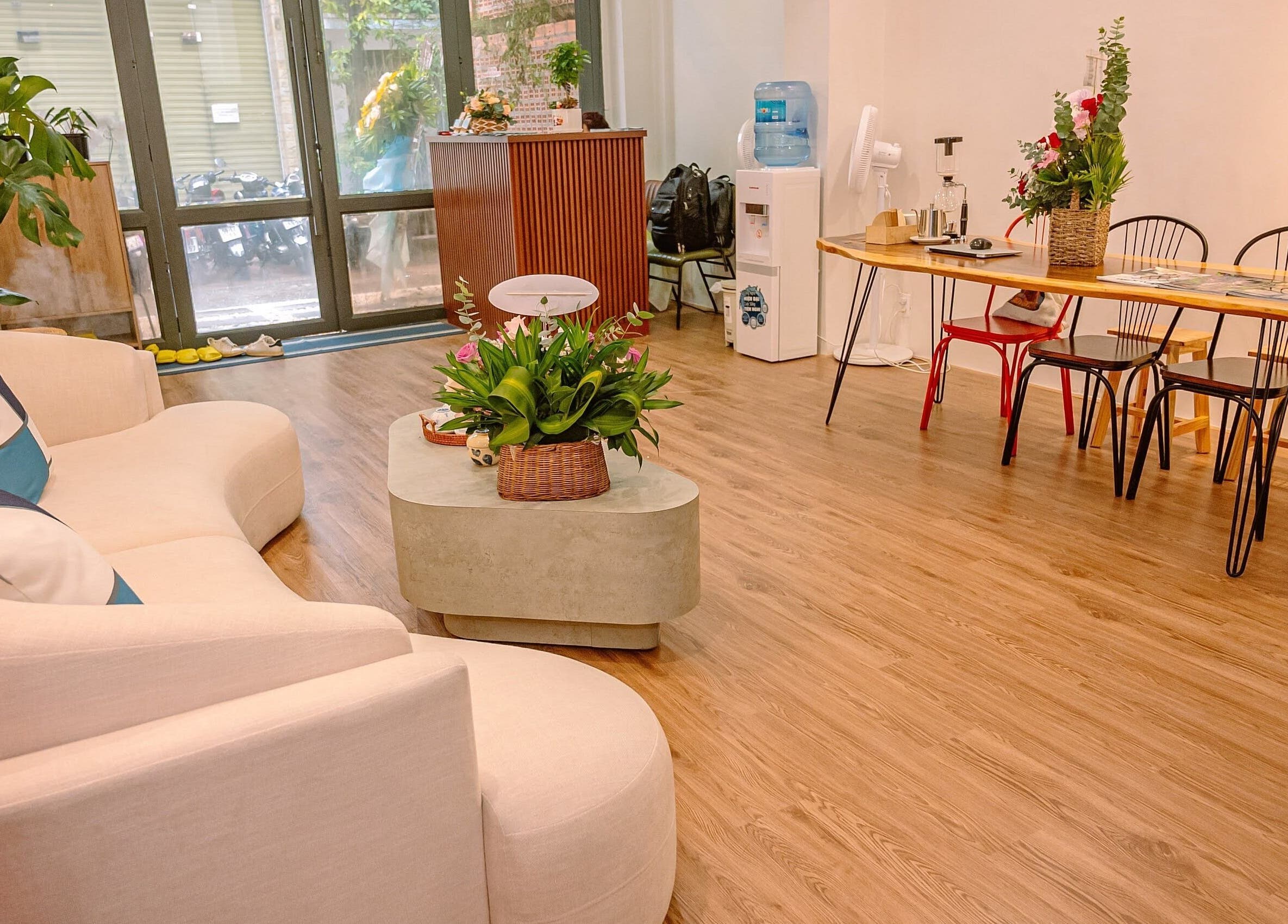 Relaxing lounge area at The Spa&Aodai, Hồ Chí Minh, VN with a plush sofa and vibrant greenery.