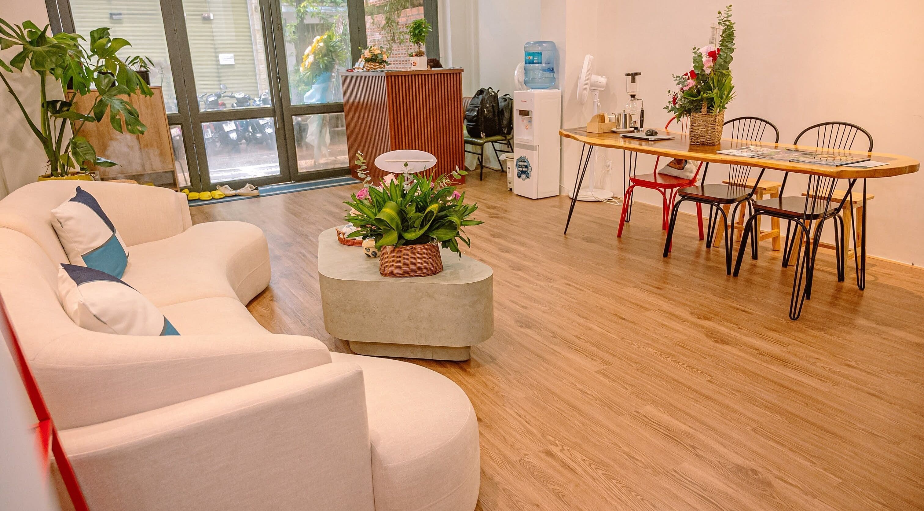 Relaxing lounge area at The Spa&Aodai, Hồ Chí Minh, VN with a plush sofa and vibrant greenery.