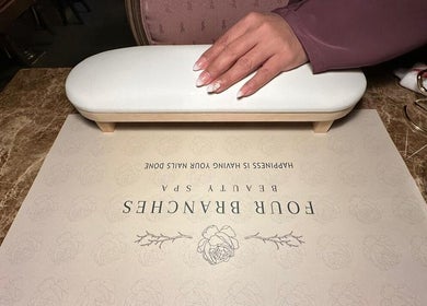 Professional manicure at Four Branches Spa Beauty, Riyadh, enhancing nails on a marble table.