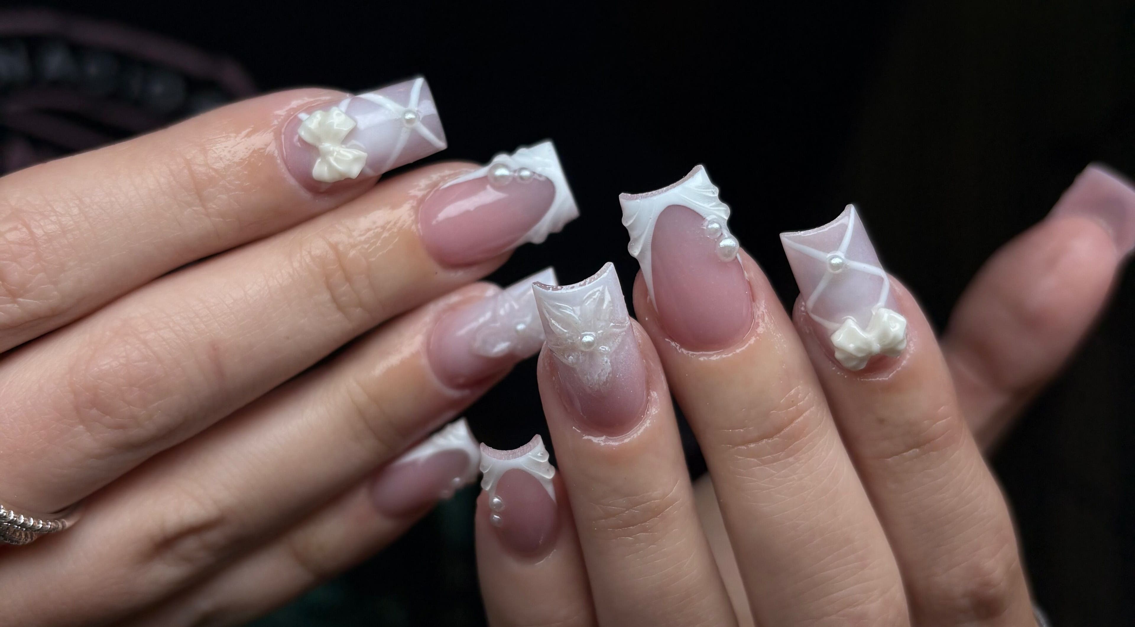 Intricate 3D nail art featuring bows and pearls at NSNails+ in Tampa, Florida, US.