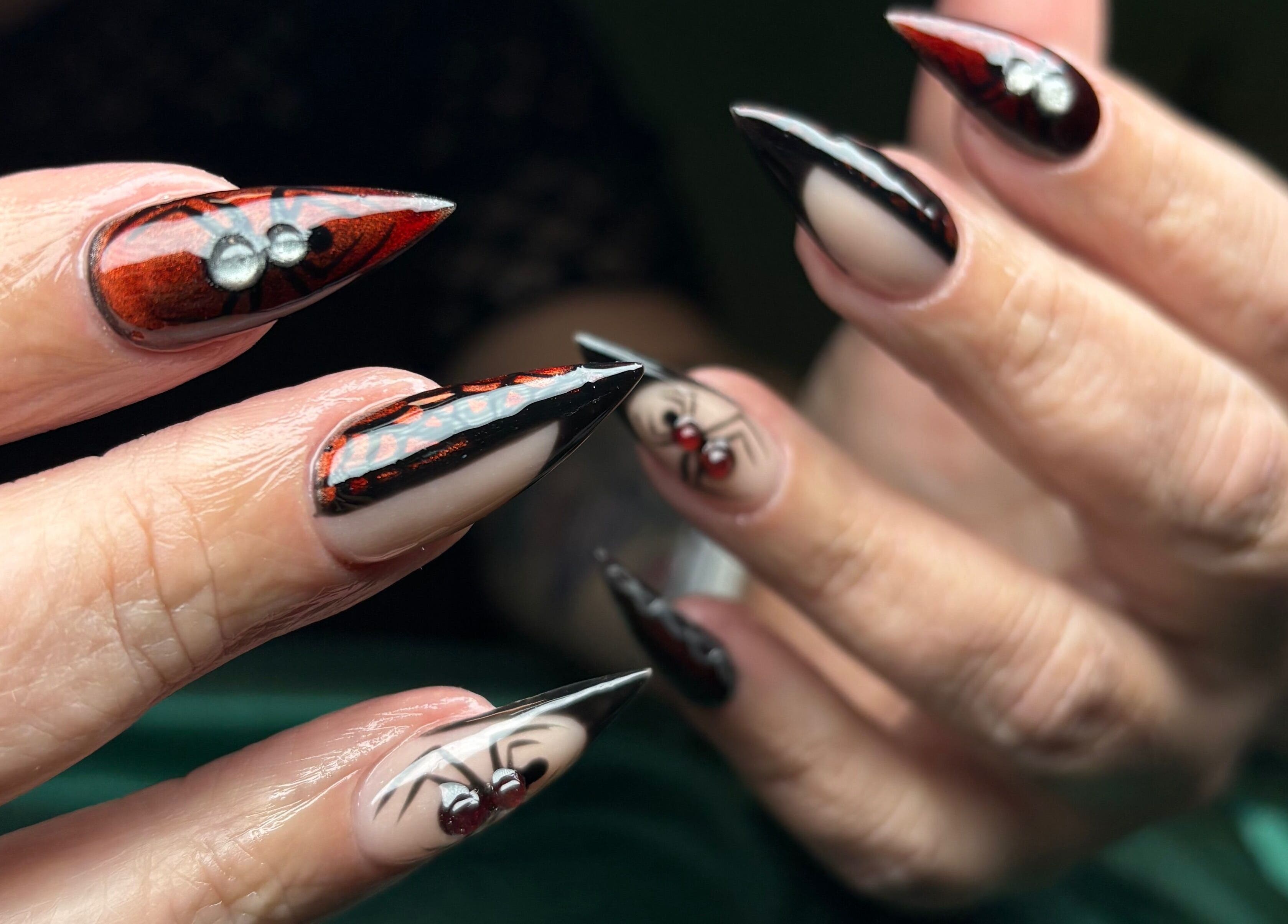 Exquisite nail art with red-black spider design at NSNails+ in Tampa, Florida, US.