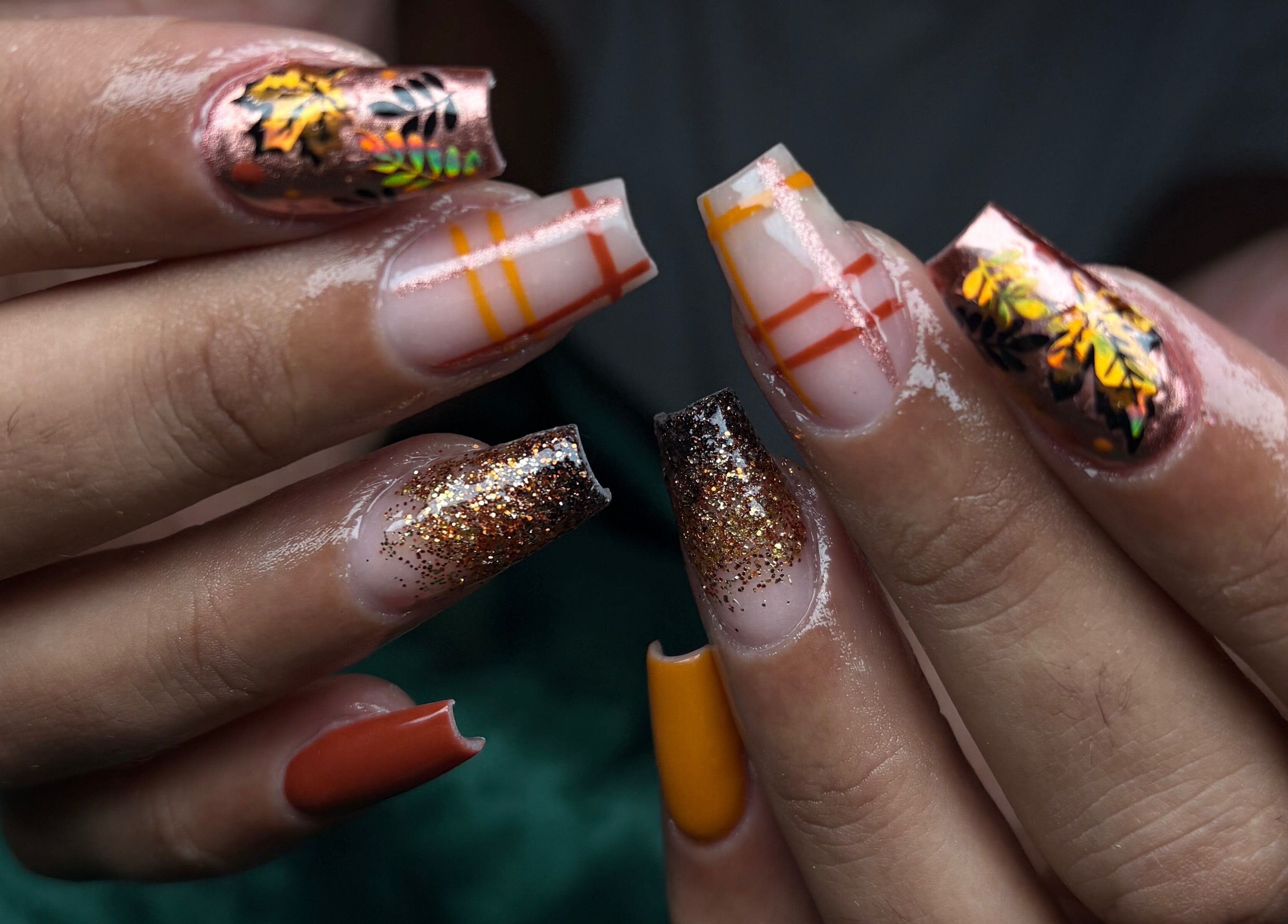 Autumn-themed nail art at NSNails+ in Tampa, Florida, US: fall leaves and glitter design.