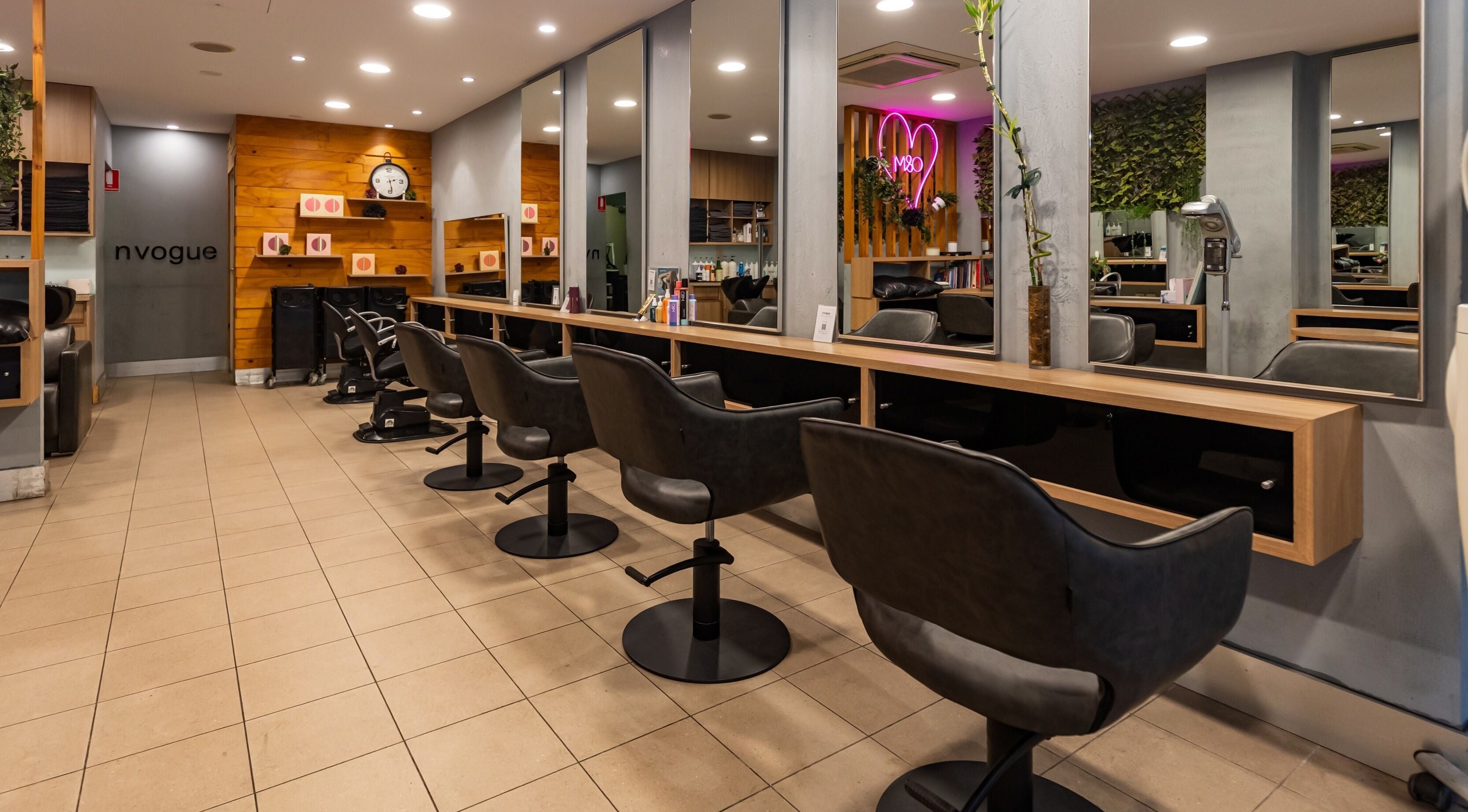 Modern salon interior at nvogue, Chatswood, NSW, AU with sleek styling chairs and mirrors.