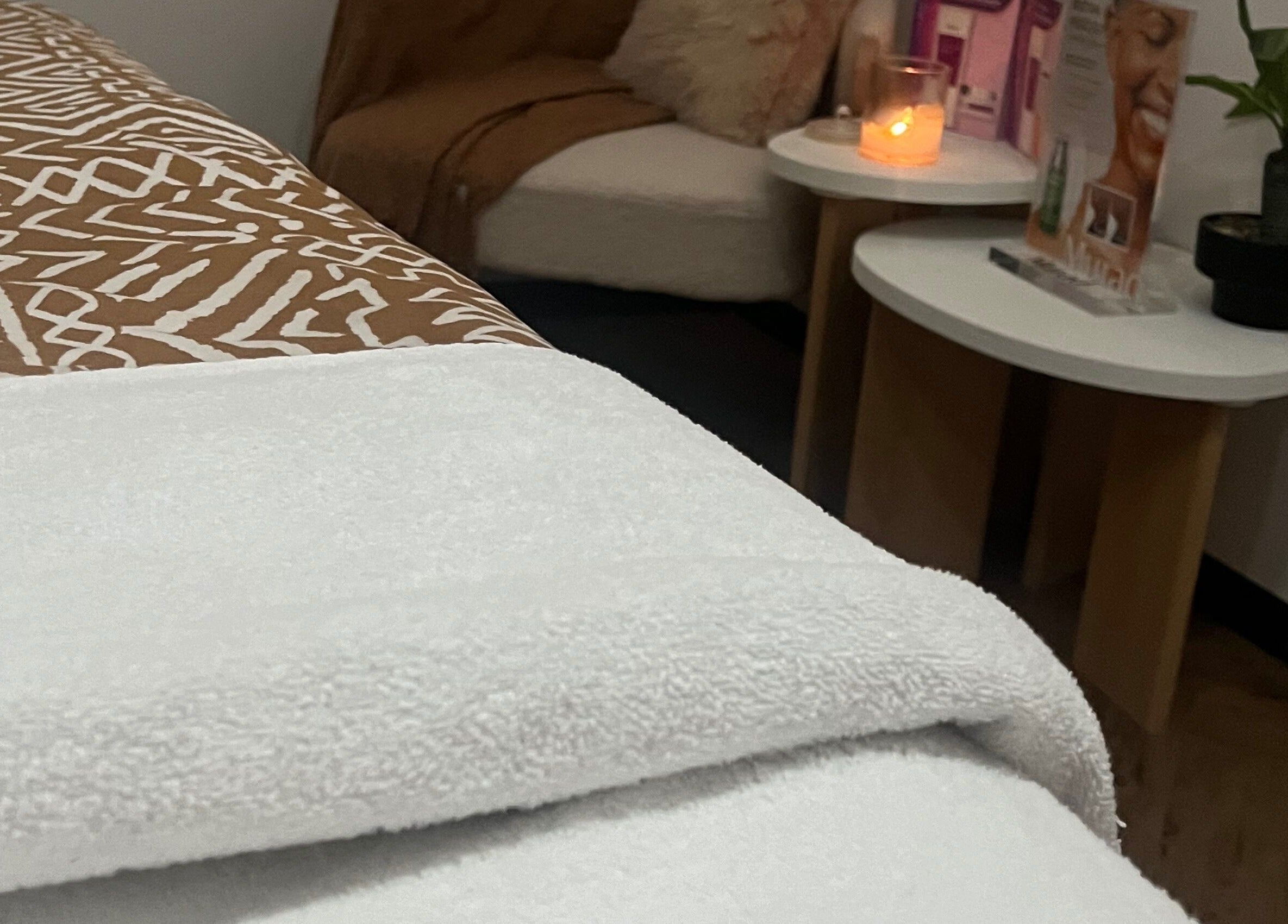 Relaxing treatment room at Bae Aesthetic Studio, Rothwell, Queensland, AU with warm lighting and plush decor.