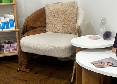 Relaxing skincare corner at Bae Aesthetic Studio, Rothwell, Queensland, AU with plush seating and beauty products.
