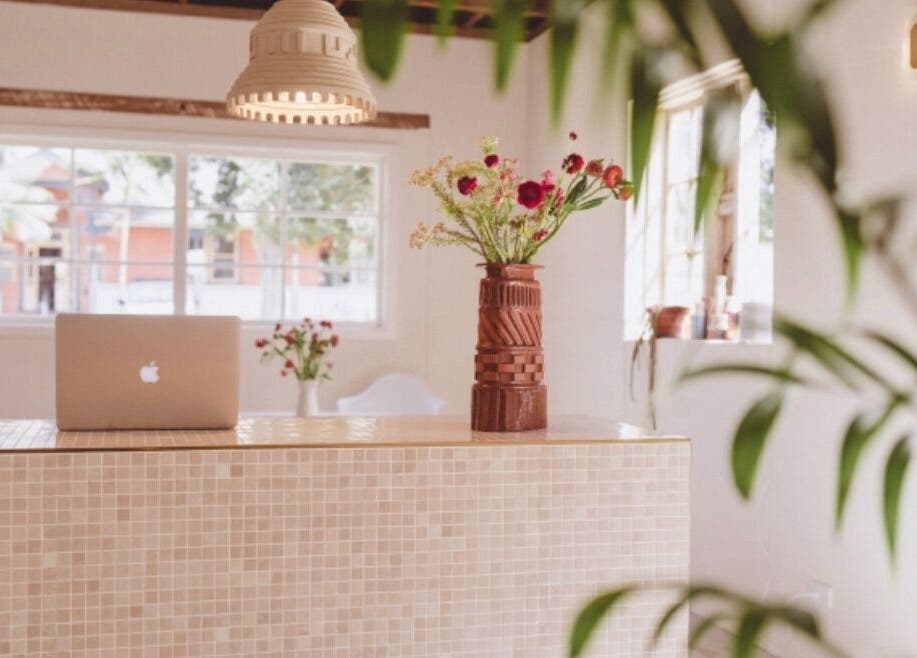 Reception desk with laptop and flowers at JoiE Beauty Salon, Auckland, Auckland, NZ.