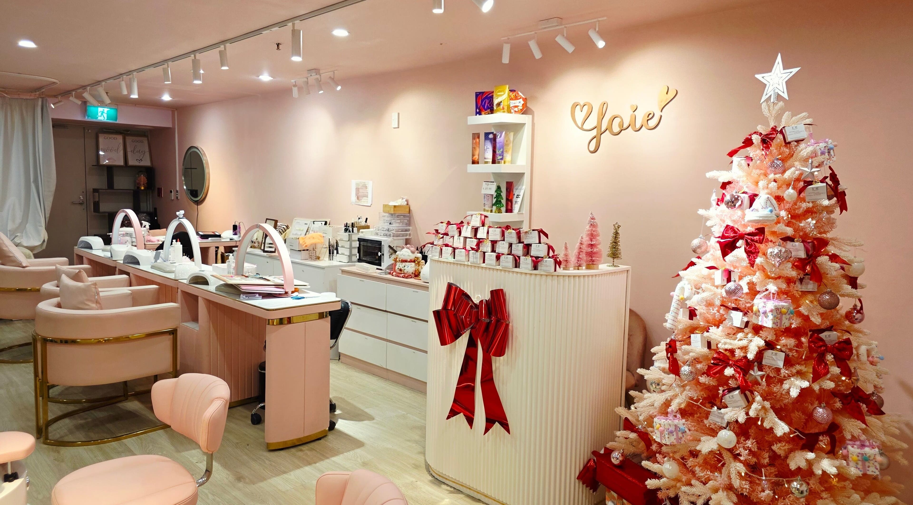 Elegant interior of JoiE Beauty Salon, Auckland, NZ with pink decor and a festive Christmas tree.