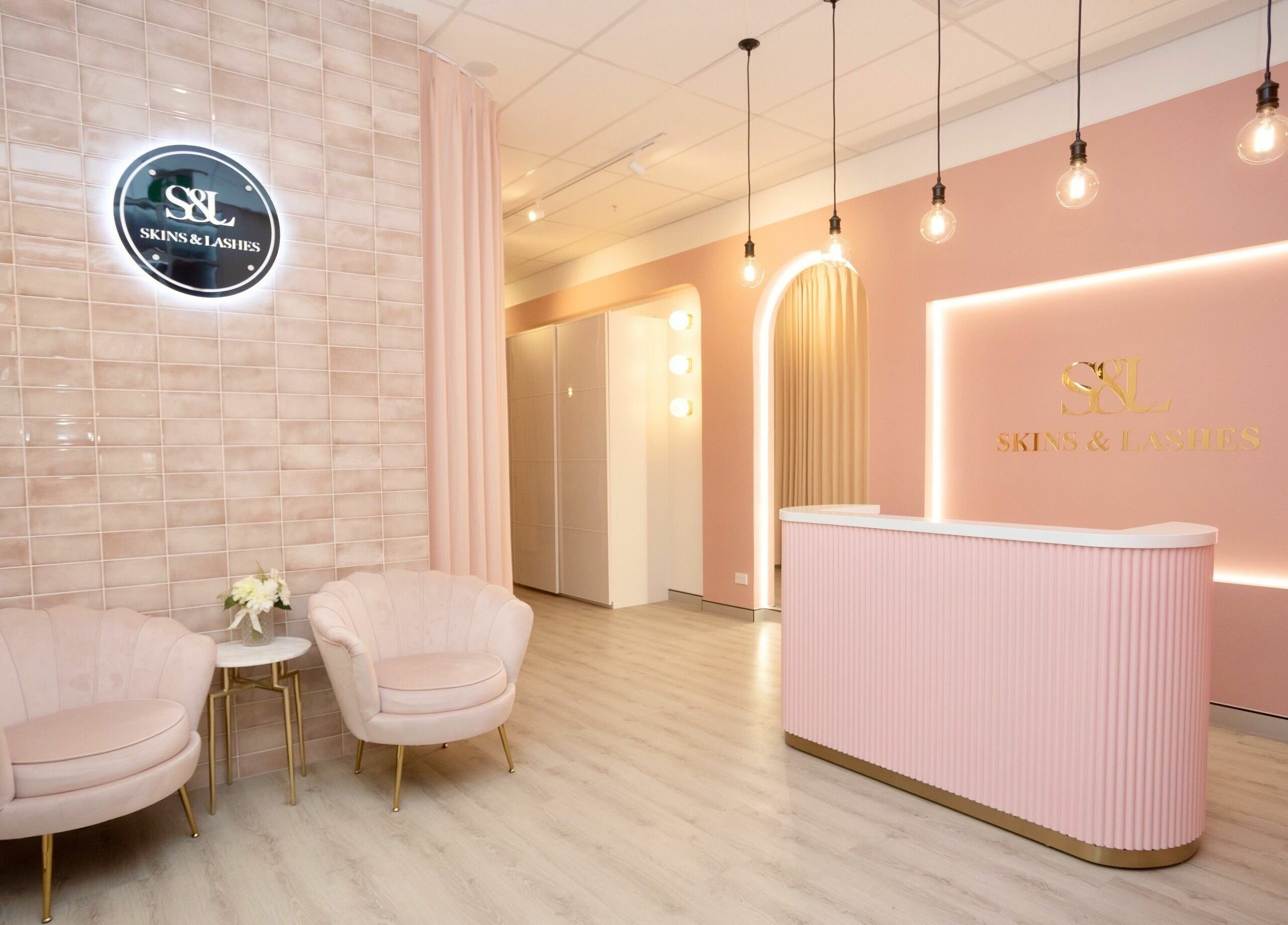 Chic reception area at S&L Skins and Lashes in Burwood, New South Wales, AU, with pastel pink decor and modern design.