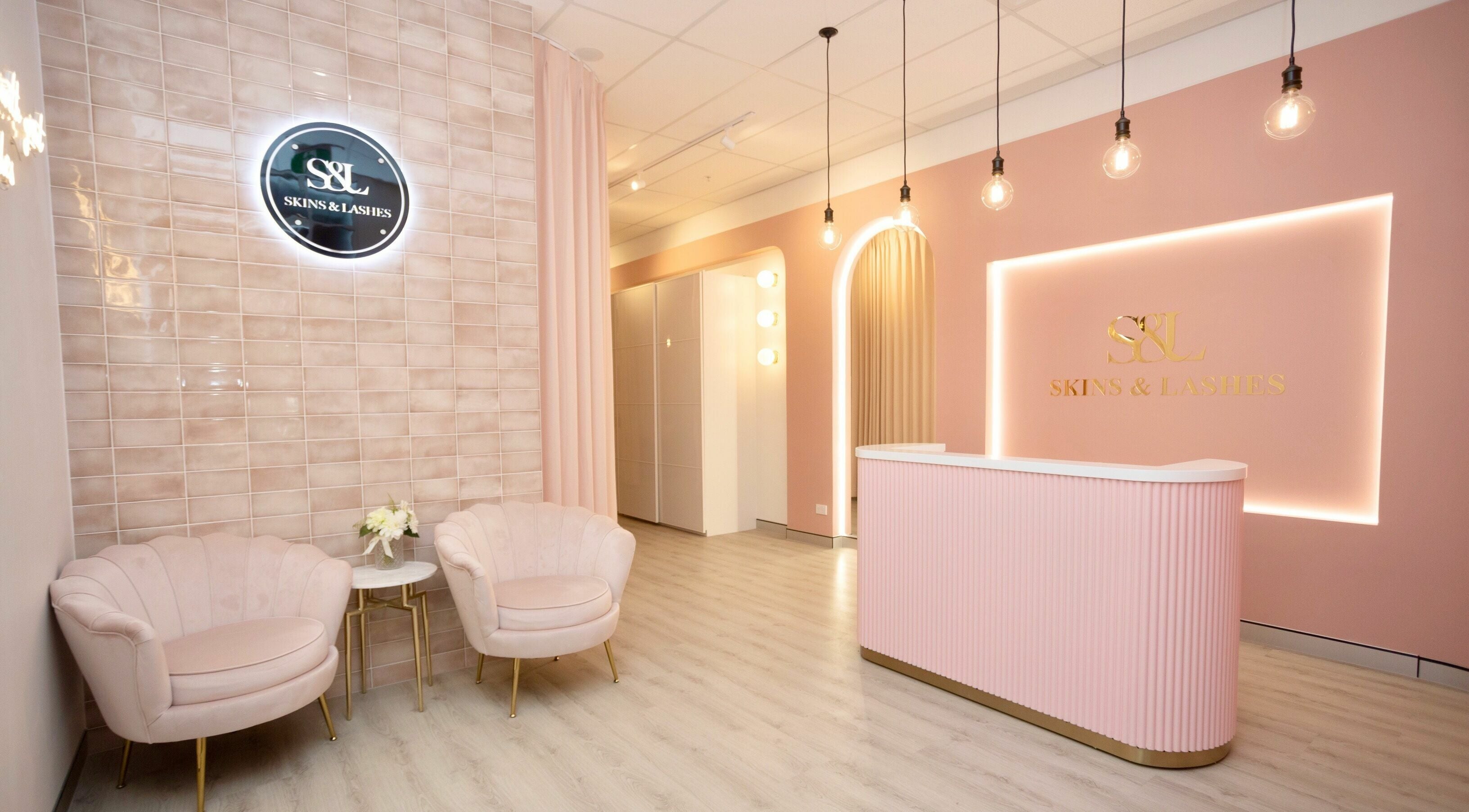 Chic reception area at S&L Skins and Lashes in Burwood, New South Wales, AU, with pastel pink decor and modern design.