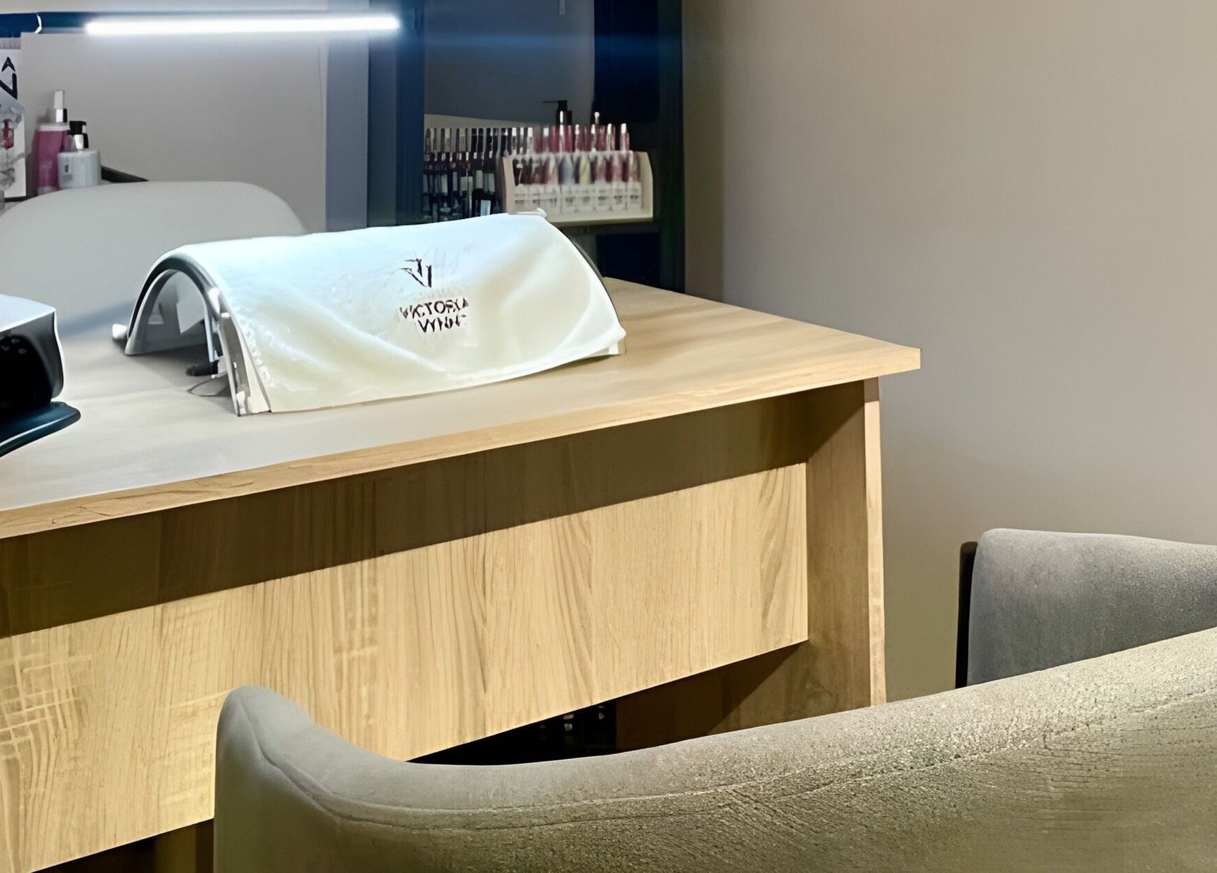 Mesa de uñas en Radiance, Zaragoza, Aragón, ES, con lámpara moderna y sillas acolchadas.