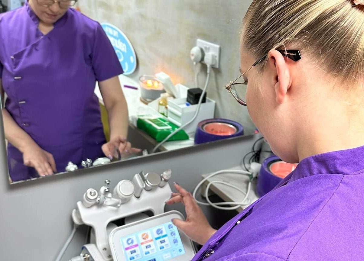 Aesthetician operates equipment at Naturally U, Sittingbourne, England, GB for advanced skincare treatments.