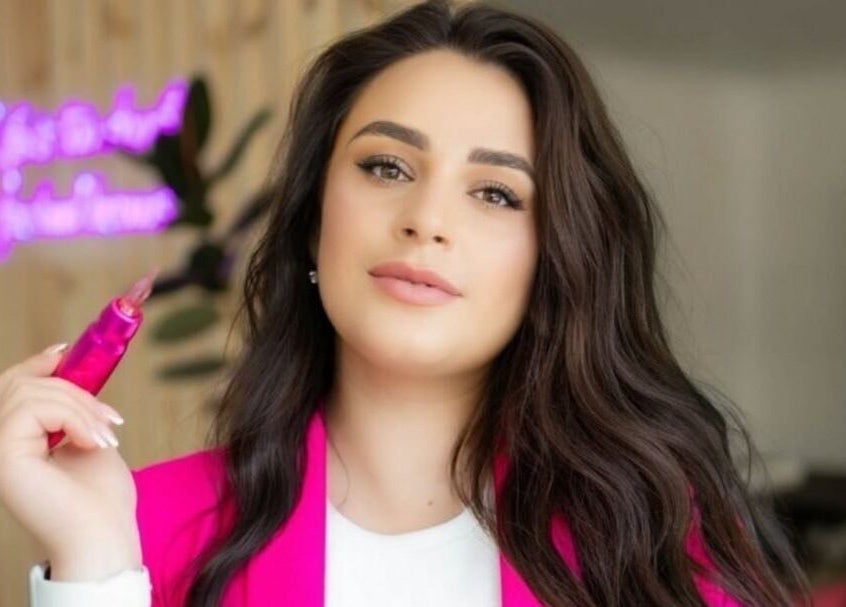 Woman holding pink lip gloss at Naturally U, Sittingbourne, England, GB.