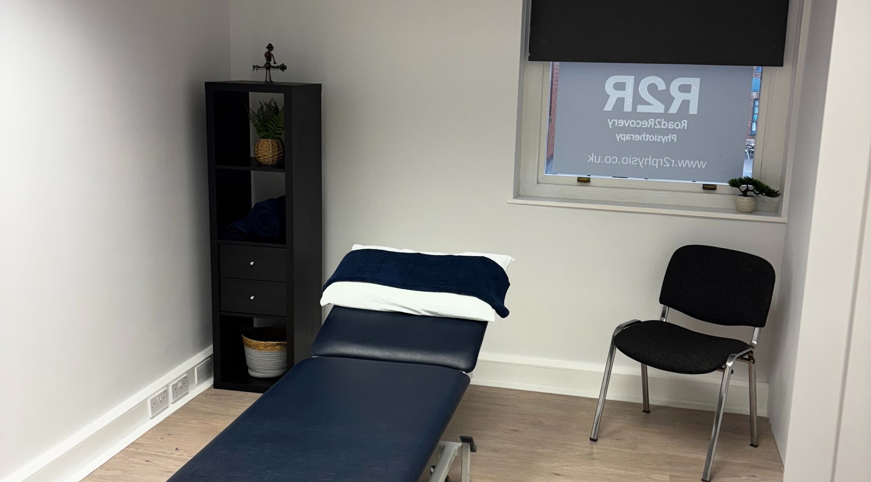 Therapy room at R2R Physiotherapy Braintree, Braintree, England, GB showing a massage table and chair.