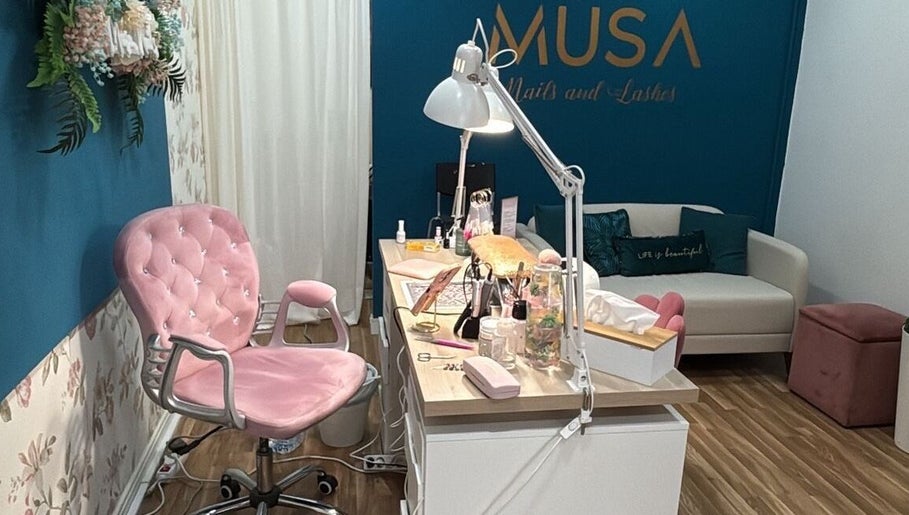 Interior do MUSA BEAUTY CONCEPT, Felgueiras, Porto, PT, mostrando cadeira rosa e mesa de tratamentos.