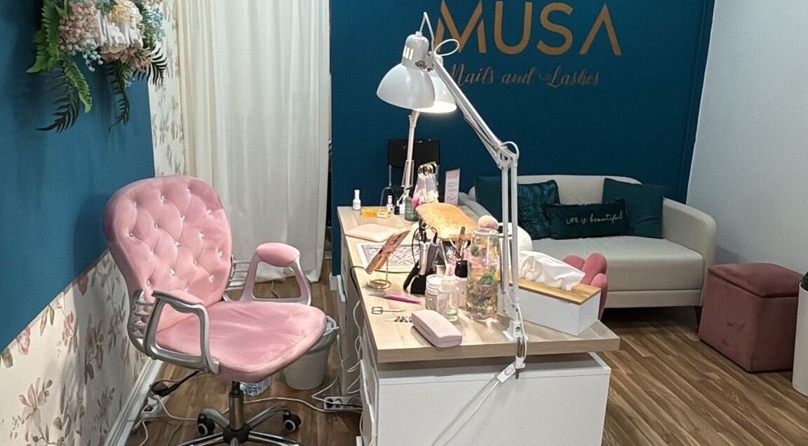 Interior do MUSA BEAUTY CONCEPT, Felgueiras, Porto, PT, mostrando cadeira rosa e mesa de tratamentos.