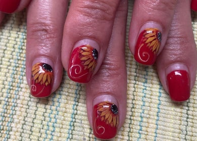 Sunflower nail art at Rala Mayer Nail and Beauty, Delmas, Mpumalanga, ZA, showcasing red lacquer with floral design.