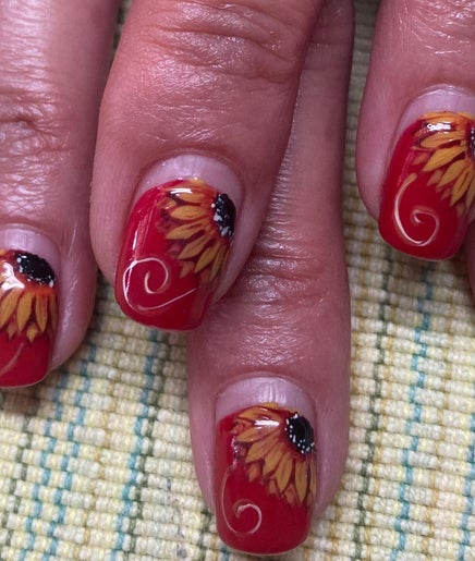Sunflower nail art at Rala Mayer Nail and Beauty, Delmas, Mpumalanga, ZA, showcasing red lacquer with floral design.