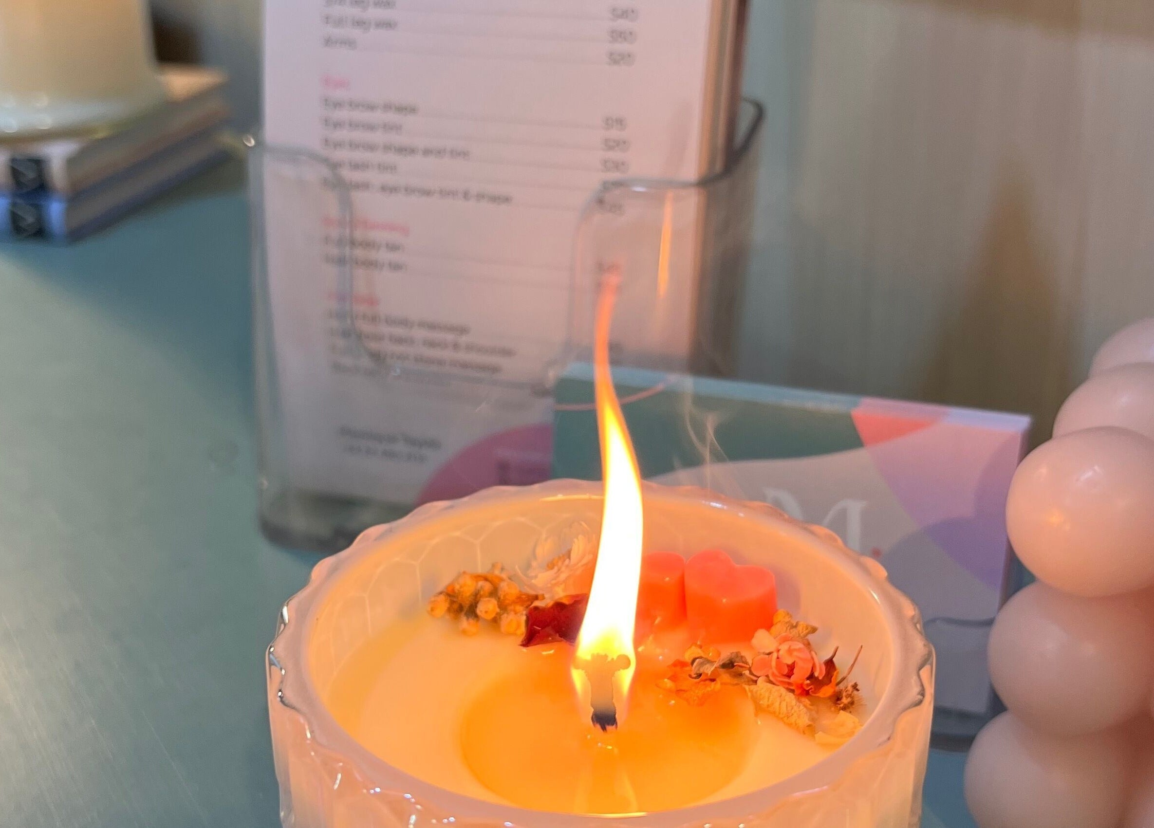 A lit aromatic candle at Studio M, Horsham Downs, Waikato, NZ, creates a relaxing ambiance with soft lighting.