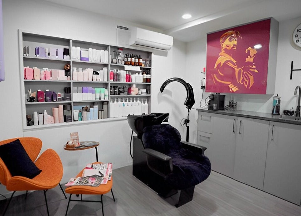 Modern salon interior at Hair by Hina Limited, Auckland, NZ, featuring styling chairs and vibrant decor.