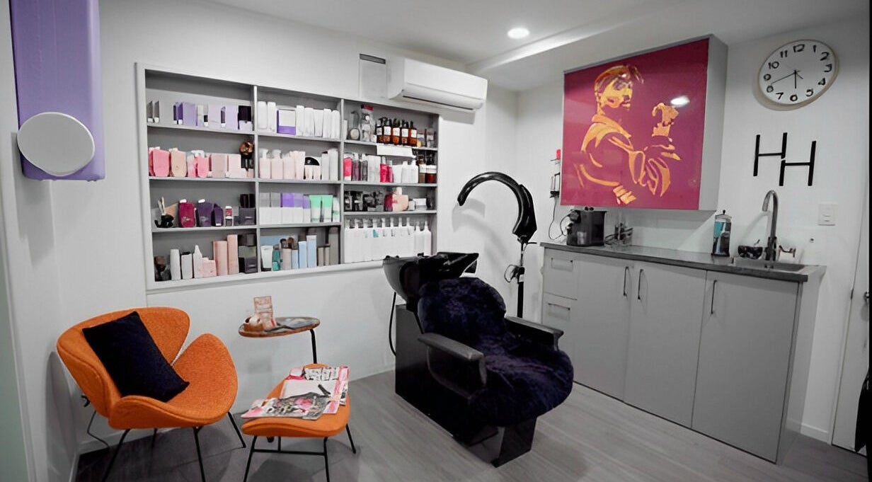 Modern salon interior at Hair by Hina Limited, Auckland, NZ, featuring styling chairs and vibrant decor.