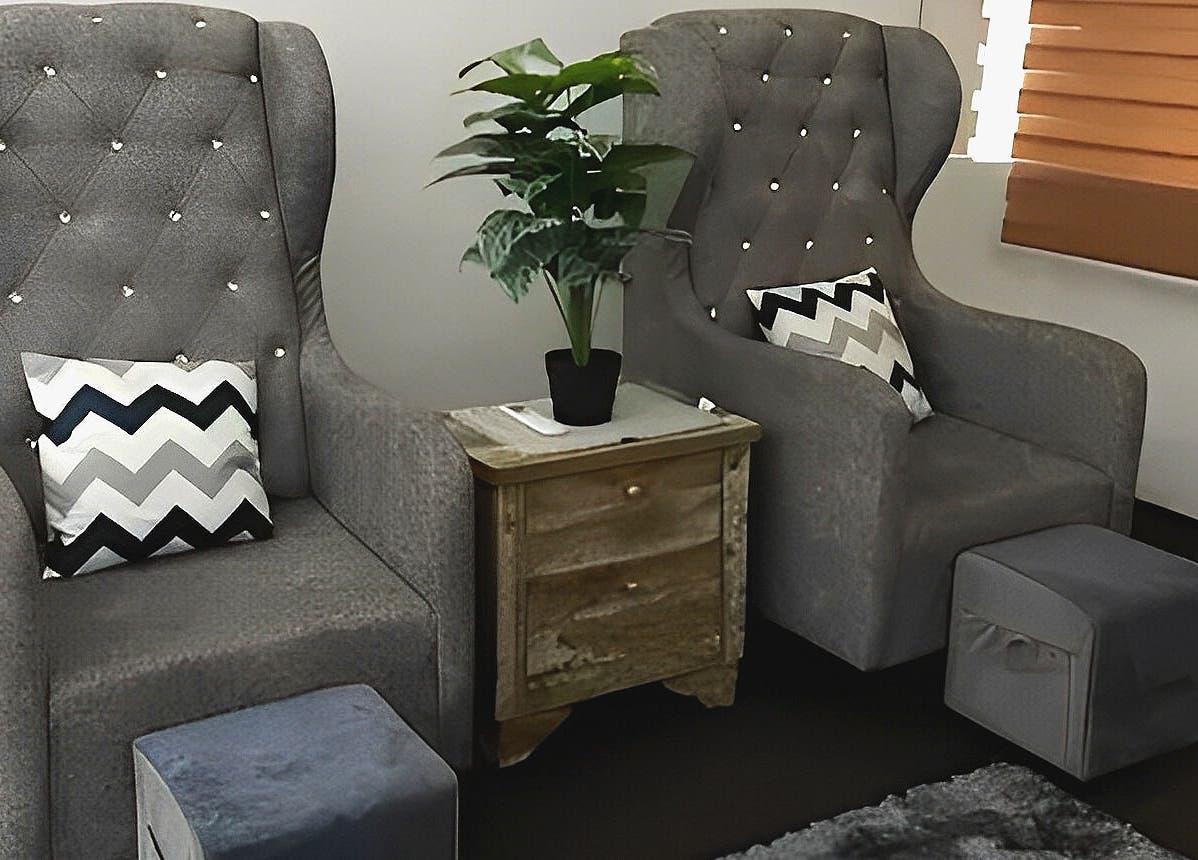 Comfortable seating at De Elvina Medispa in Muar, Johor, MY with luxurious gray chairs and chevron cushions.