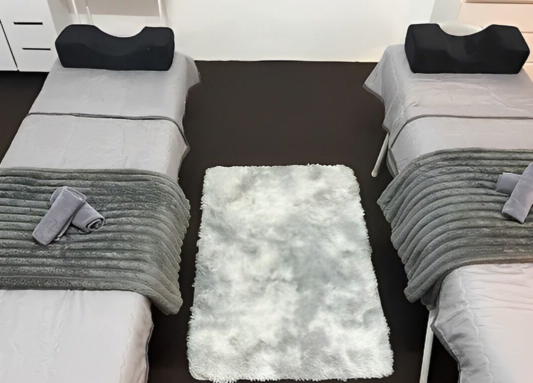 Cozy spa beds at De Elvina Medispa in Muar, Johor, MY, featuring soft towels and elegant decor.